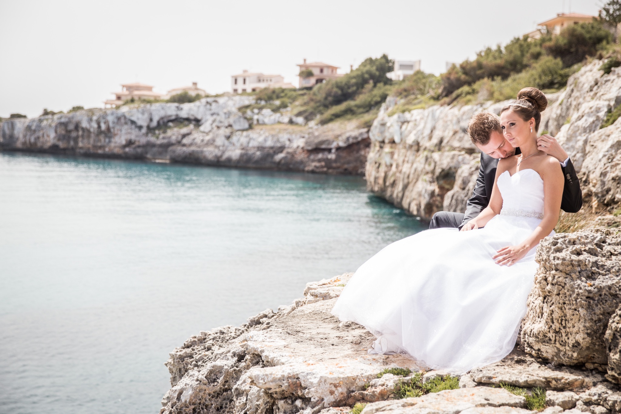 Afterwedding mallorca brautpaar sitzt an der wasserkantr zum meer