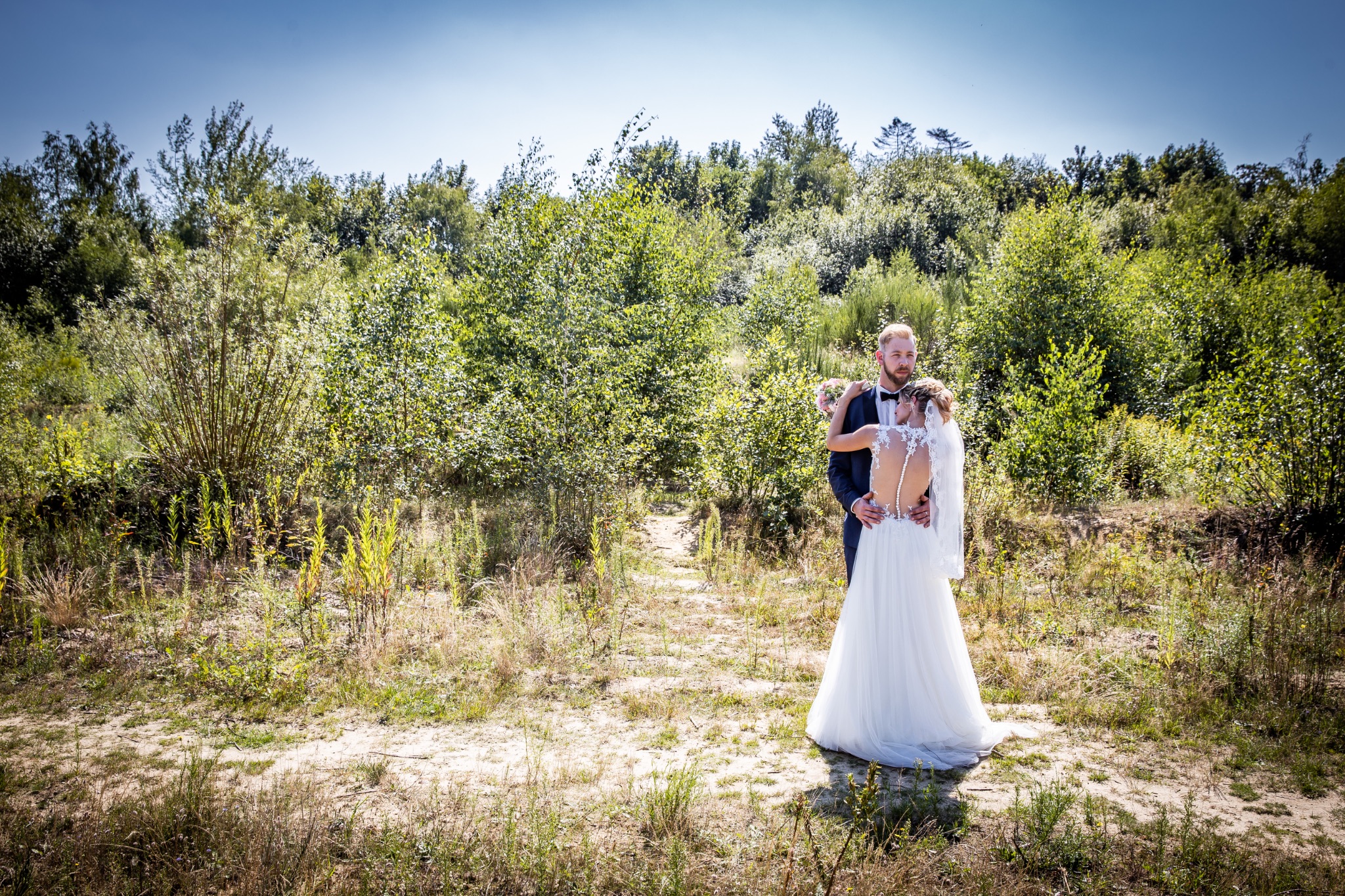 Hochzeitsportrait braut mit freien ruecken an braeutigram anlehnend