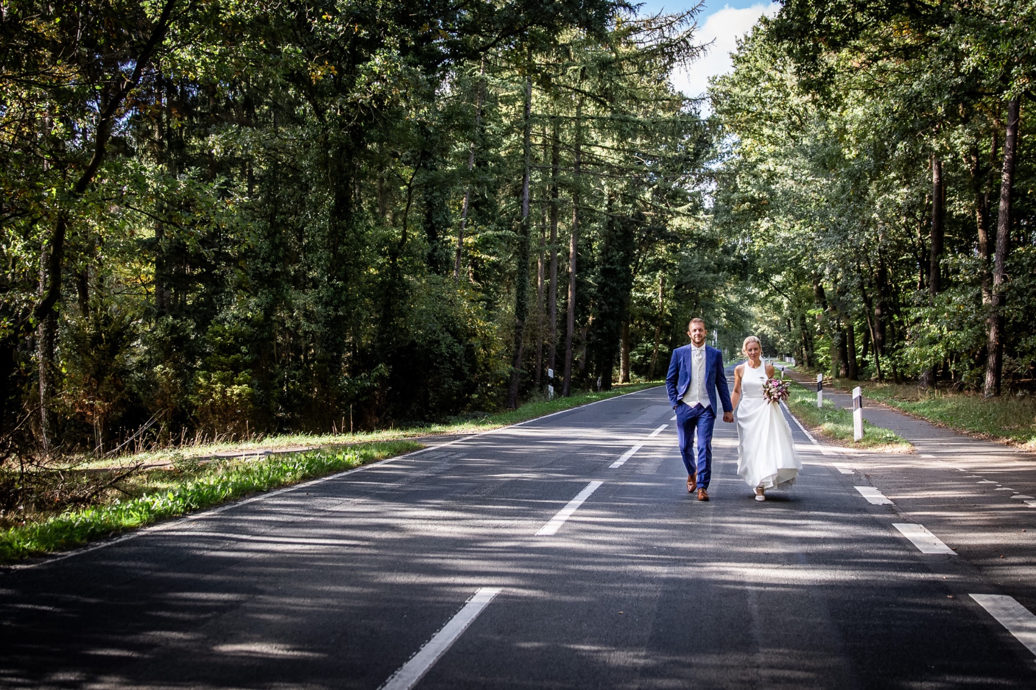 Hochzeitsportrait brautpaar gehend auf strasse