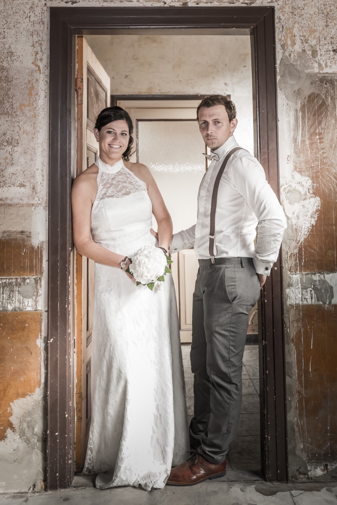 Hochzeitsportrait brautpaar im alten gebaeude an tuerzarge anlehnend