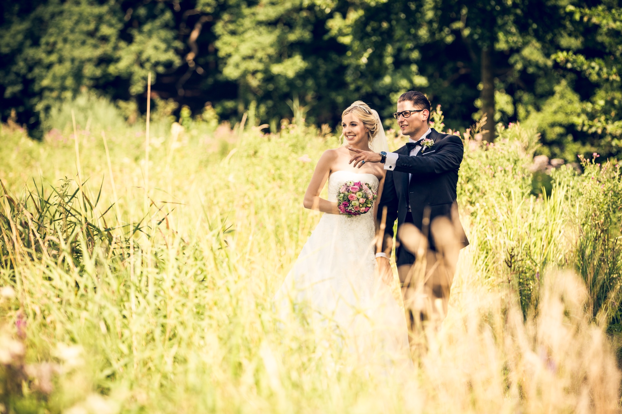Hochzeitsportrait brautpaar im hohen gras braetigram zeigt braut was