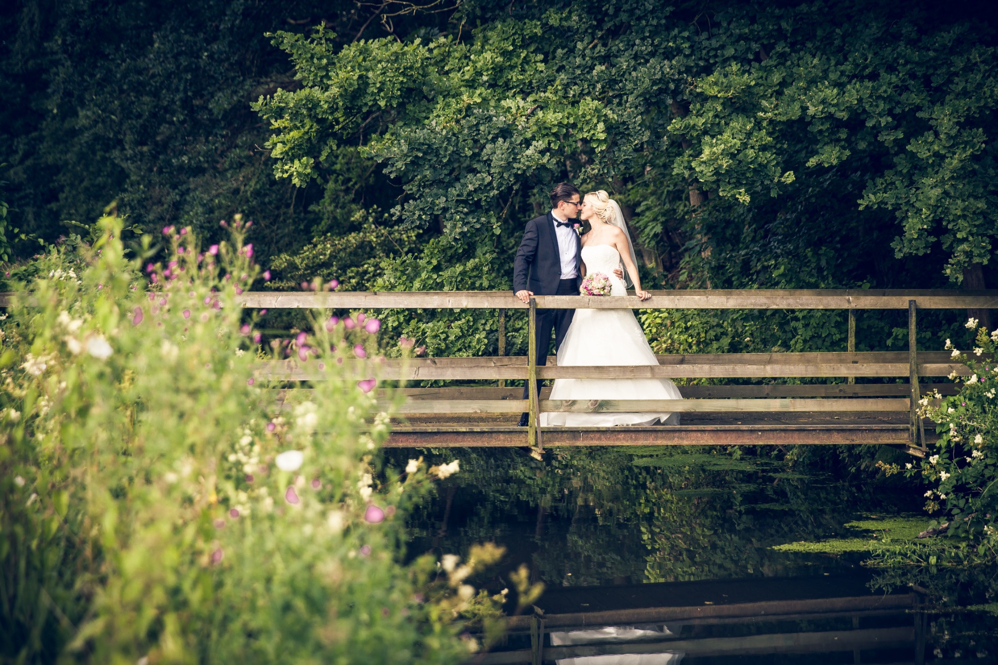 Hochzeitsportrait brautpaar steht am bruecke